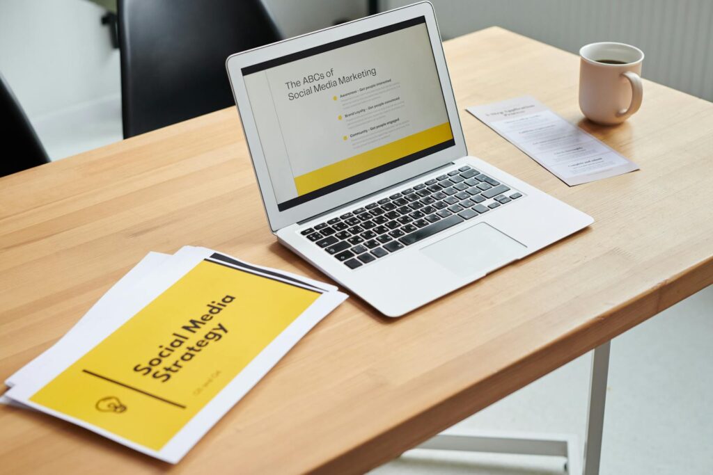 Close-Up Shot of a Laptop beside Paper Documents